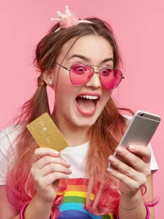A young and happy girl holding her Discover it Student Cash Back.