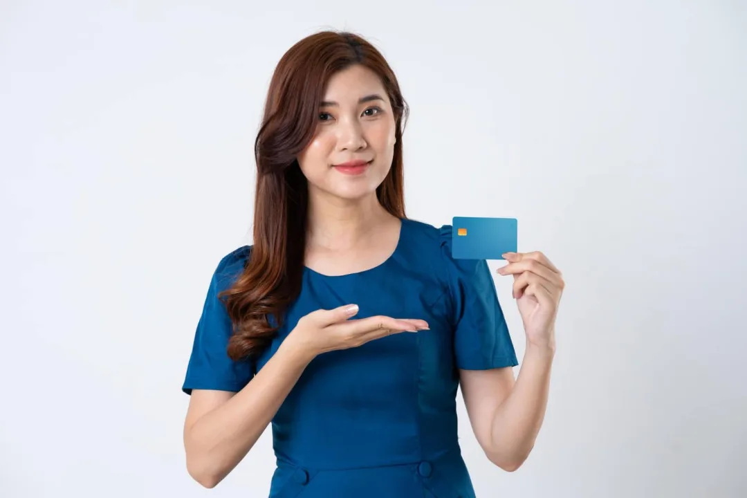 A woman holding a Capital One Platinum credit card.