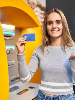 A woman holding her U.S. Bank Cash+ Visa Signature Card.