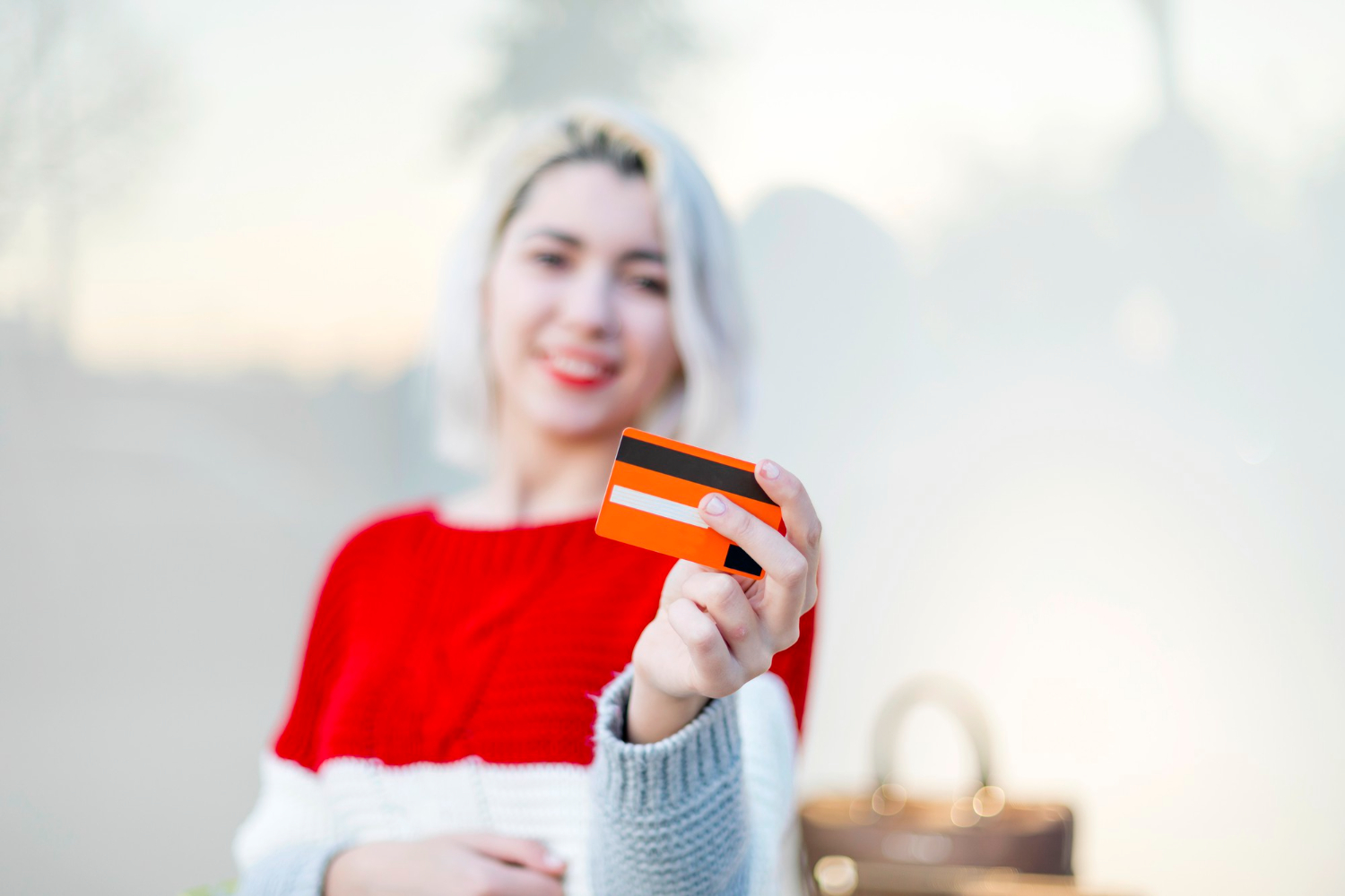 A woman holding her Wells Fargo Health Advantage credit card.