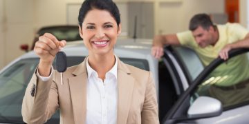 Happy woman holding her car keys after a Bank of America Auto Loan.