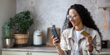 Woman using Online Checking Accounts oh her cellphone.